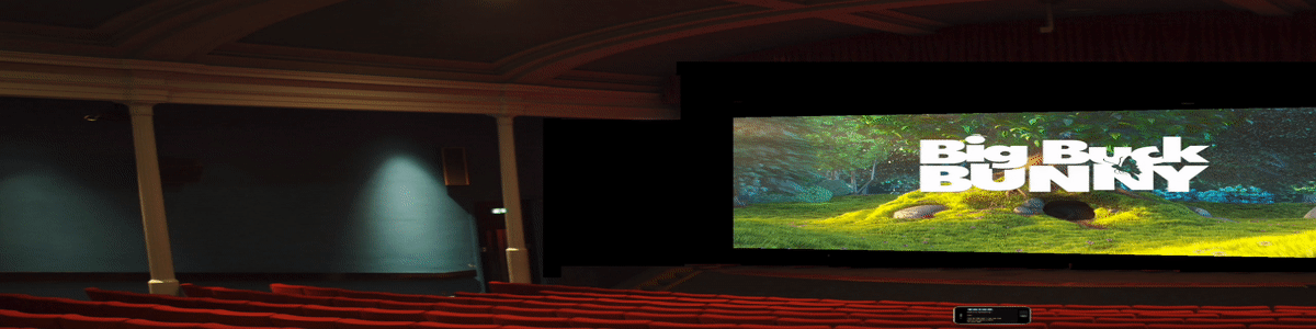 A theater interior. There are iphones at a few seats showing captions.